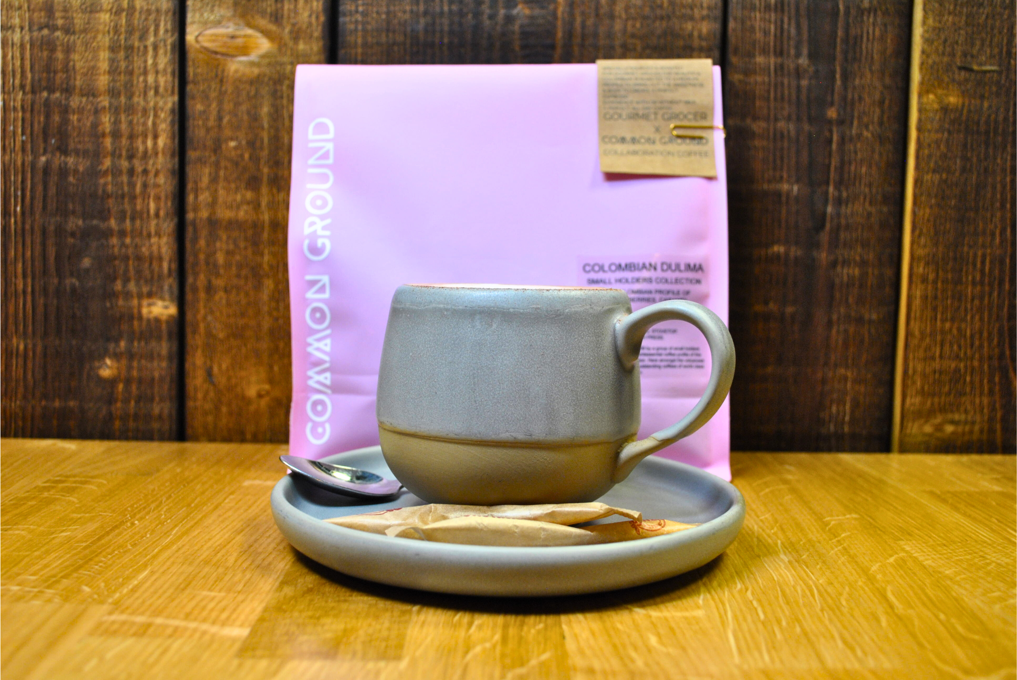 Common Ground Colombian Dulima Coffee in stonewear mug with saucer and brow sugar sachets