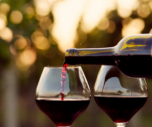 pouring glasses of red wine from bottle
